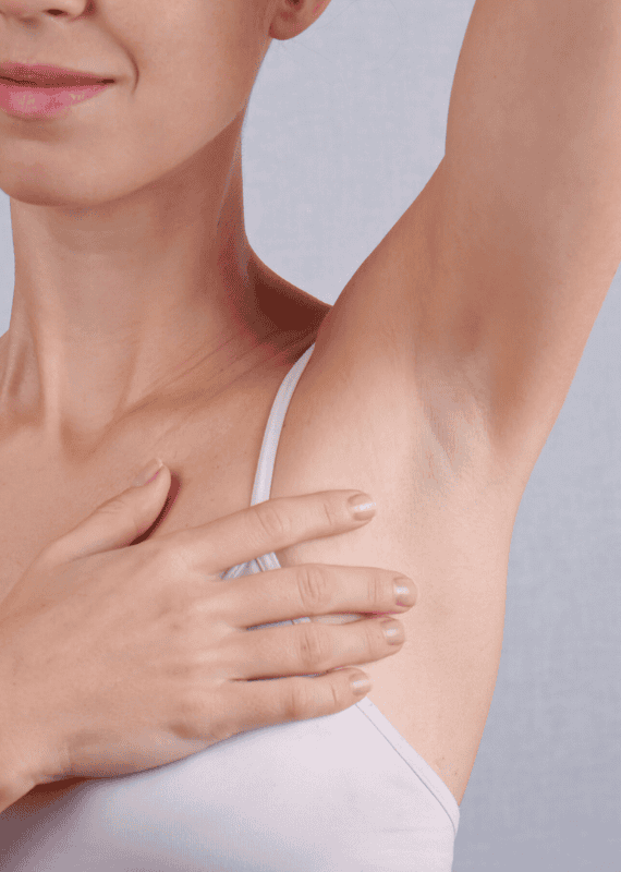 Woman with arm raised showing armpit with no hair